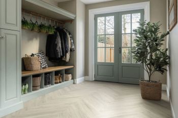 boot room in hallway with beige herringbone wooden flooring and sage green walls